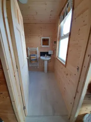 a bathroom with a sink in a wooden cabin at The Hut B & B in Mochdre