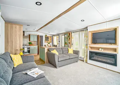 a living room with a couch and a tv at Ocean Heights Holiday Park in New Quay