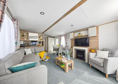 a living room with a couch and a fireplace at Ocean Heights Holiday Park in New Quay