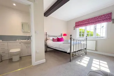 a bedroom with a bed and a sink and a window at Marrington Farmhouse in Chirbury