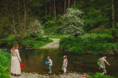 a group of people standing in the water in a creek at Marrington Farmhouse in Chirbury