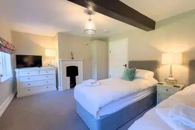 a bedroom with a bed and a dresser and a fireplace at Marrington Farmhouse in Chirbury