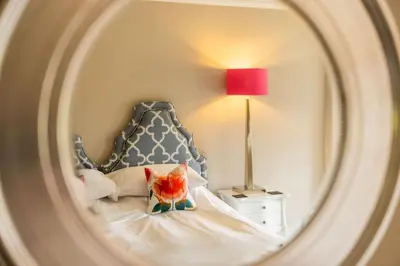 a bedroom with a bed with a headboard and a lamp at Marrington Hall in Chirbury