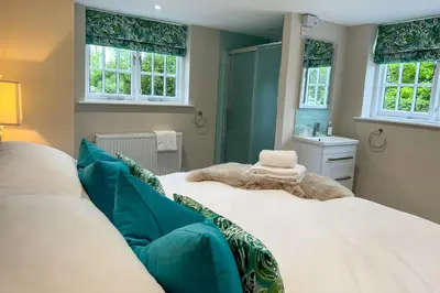 a bedroom with two beds and a sink and windows at Marrington Hall in Chirbury