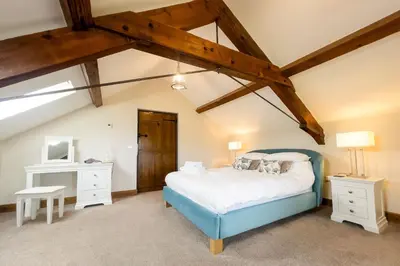a bedroom with a blue bed in a attic at Camlad Barn in Chirbury