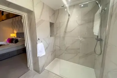 a bathroom with a walk in shower and a glass shower stall at Roundton Farmhouse in Chirbury