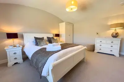 a bedroom with a large bed with two night stands at Roundton Farmhouse in Chirbury