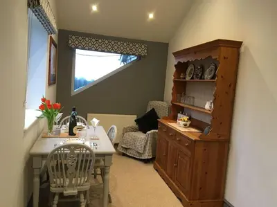 a living room with a table and a chair at Ravens Rest in Llanwrda