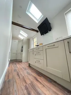a large kitchen with white cabinets and a skylight at Georgian 3 bed house in historic town centre in Shrewsbury