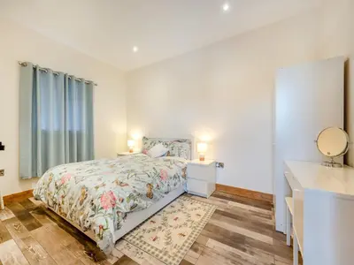 a bedroom with a bed and a bathroom with a sink at Ty Gwair - Uk41512 in Lampeter