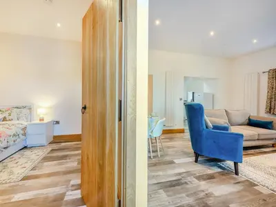 a living room with a couch and a blue chair at Ty Gwair - Uk41512 in Lampeter
