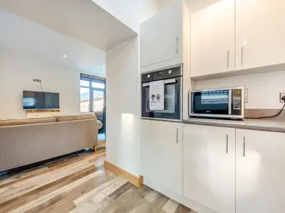 a kitchen with white cabinets and a microwave at Ty Gwair - Uk41512 in Lampeter