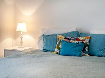 a bed with blue pillows and a lamp on it at Brynog Mansion Apartment in Cilcennin