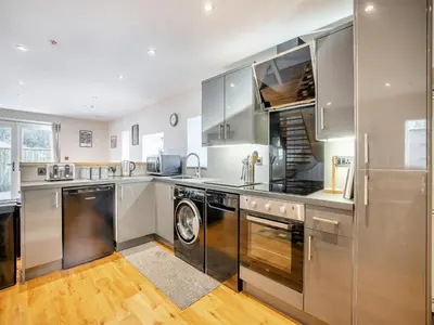 a kitchen with stainless steel appliances and a washer and dryer at Yr Hen Beudy in Tregaron