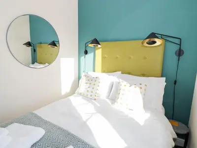 a bedroom with a white bed with a mirror at The Stokesay in Ludlow