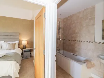 a bedroom with a bed and a tub and a sink at The Stokesay in Ludlow