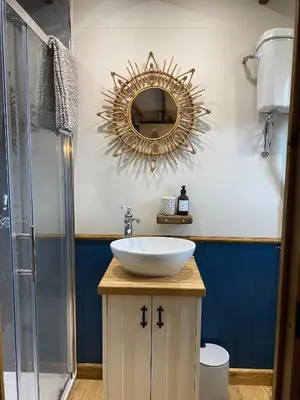 a bathroom with a sink and a mirror on the wall at Silver Fern Glamping in Aberystwyth
