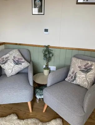two chairs and a table in a living room at Silver Fern Glamping in Aberystwyth