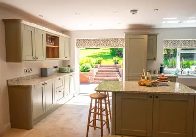 a kitchen with white cabinets and a large island at Country Crabtree Bungalow with large wild garden in Leighton