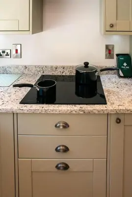 a kitchen counter with two pots on a stove at Country Crabtree Bungalow with large wild garden in Leighton