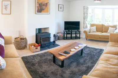 a living room with a coffee table and a fireplace at Country Crabtree Bungalow with large wild garden in Leighton