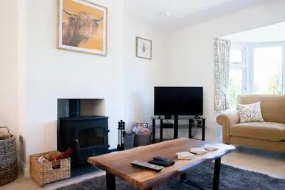 a living room with a coffee table and a fireplace at Country Crabtree Bungalow with large wild garden in Leighton