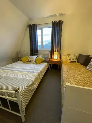 a bedroom with two beds and a window at Holiday home, Tywyn, great location in Tywyn