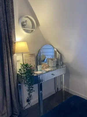 a room with a table with a mirror and a lamp at Holiday home, Tywyn, great location in Tywyn