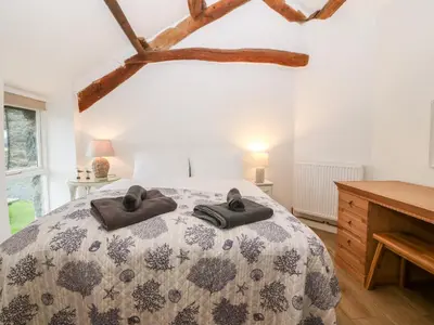 a bedroom with a bed with two towels on it at Y Bwthyn in Dyffryn