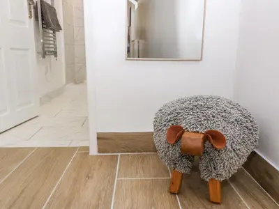a stuffed animal sitting on the floor in a bathroom at Y Bwthyn in Dyffryn