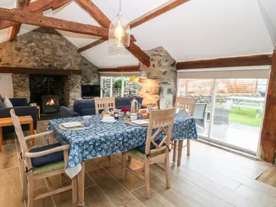 a dining room with a table and chairs and a fireplace at Y Bwthyn in Dyffryn