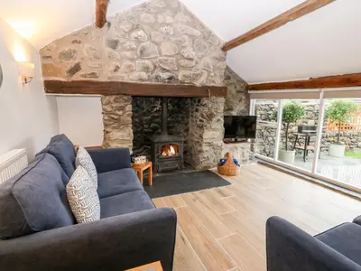 a living room with a large stone fireplace at Y Bwthyn in Dyffryn
