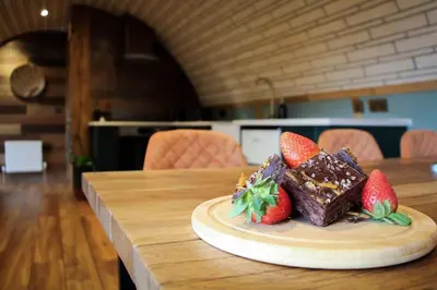 a piece of chocolate cake with strawberries on a table at Hedgehogs View in Rhayader