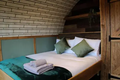 a bed with two towels and pillows on it at Hedgehogs View in Rhayader