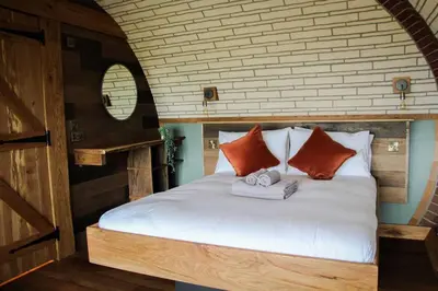 a bedroom with a bed with two towels on it at Hedgehogs View in Rhayader