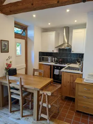 a kitchen with a wooden table and a stove at Y Swdio, Ferm Glandwr in Barmouth