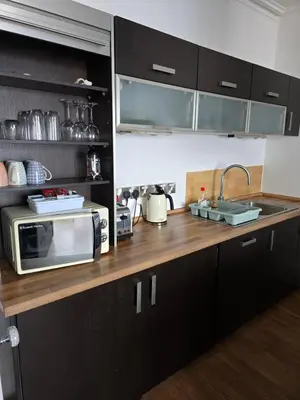 a kitchen counter with a microwave and a sink at Beautiful Seafront 1 bedroomed apartment in Aberystwyth