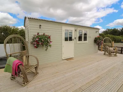 a deck with two chairs and a shed at Marches Way in Rhayader