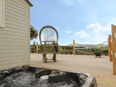 a chair sitting in a hot tub on a deck at Marches Way in Rhayader