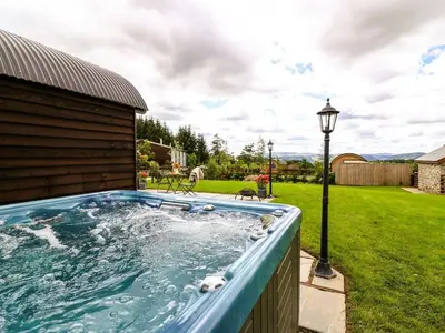 a hot tub in a yard with a light pole at Mountain View Pod in Rhayader