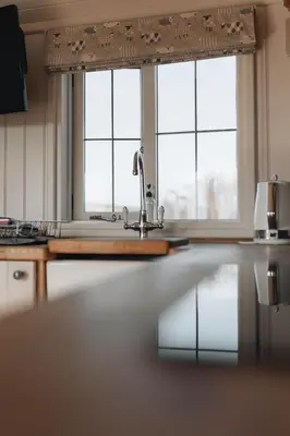a kitchen with a sink and two windows at Hillside View in Rhayader