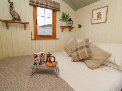 a bedroom with a white bed with a tray on it at Ivy's Way in Rhayader