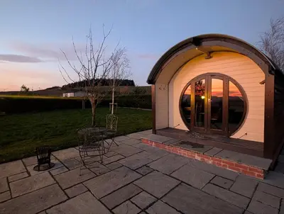 a gazebo with a glass door on a patio at Valley View Pod in Rhayader