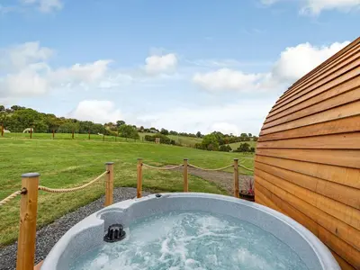 a jacuzzi tub with a view of a field at Beech Uk36260 in Llanfair Caereinion