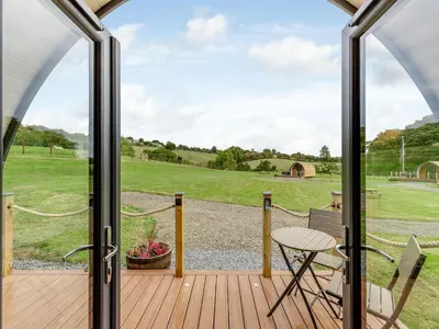a view from the deck of a home with a glass door at Beech Uk36260 in Llanfair Caereinion