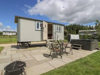 a tiny house on a patio with a table and chairs at Shepherds View in Rhayader