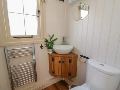 a bathroom with a toilet and a sink and a window at Shepherds View in Rhayader