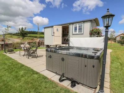 a hot tub in a backyard next to a house at Shepherds View in Rhayader