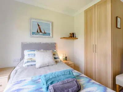 a bedroom with a bed with blue and white blankets at Bryn Teg - Cottage in Maesmynis
