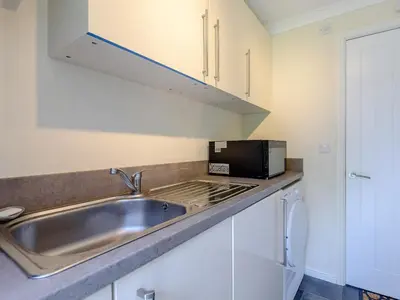 a kitchen with a sink and a microwave at Bryn Teg - Cottage in Maesmynis